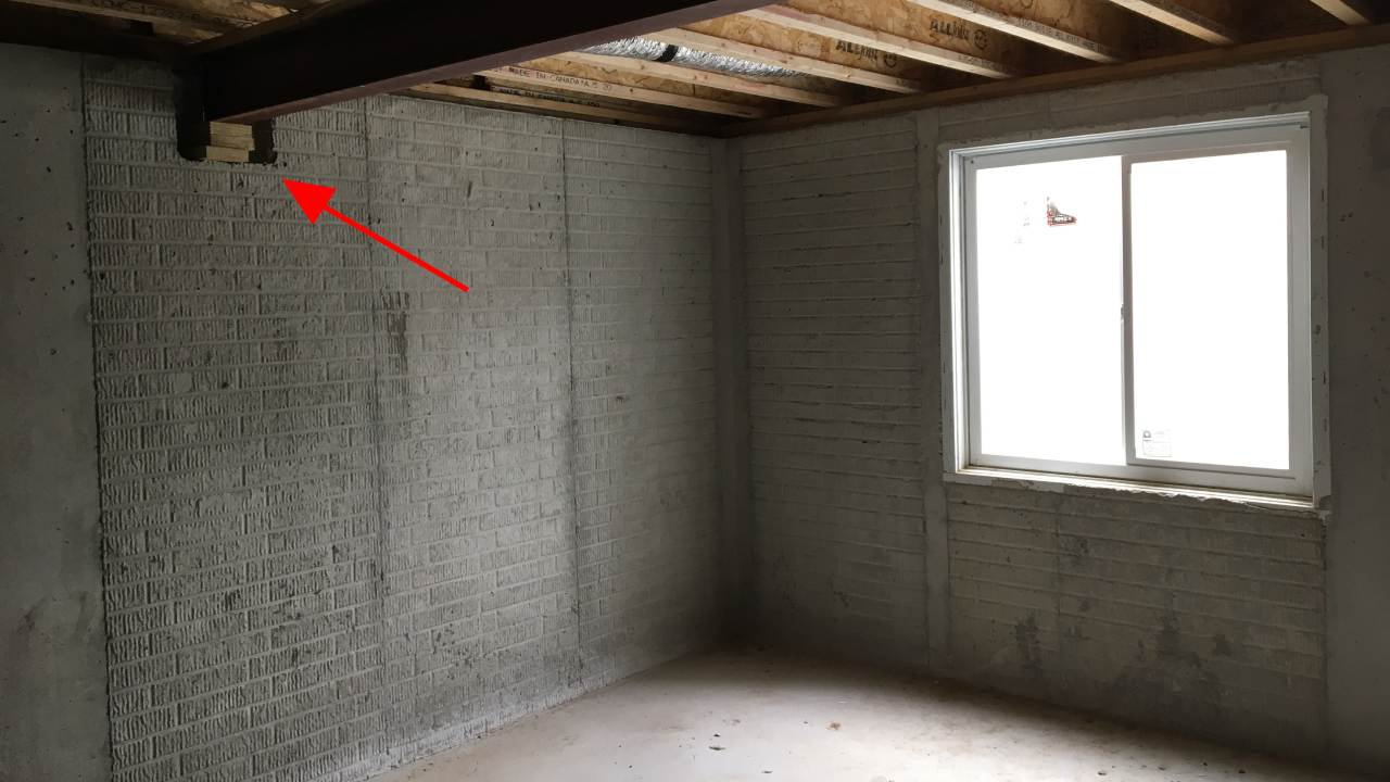 Improper beam bearing on foundation wall corrected with steel plate installation