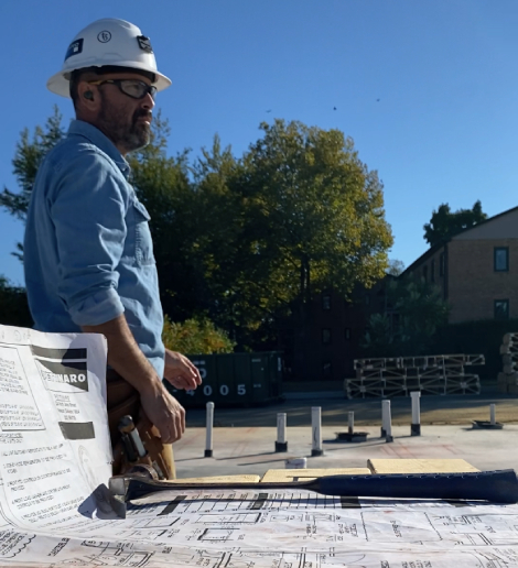 Commercial contractor reviewing blueprints on-site during pre-construction estimating and planning